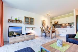 a living room with a television and a table at Residenz am Balmer See - BS 42 mit Wellnessbereich in Balm