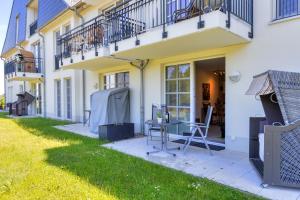 a patio with a table and chairs in front of a building at Residenz am Balmer See - BS 42 mit Wellnessbereich in Balm