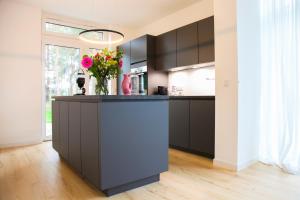 a kitchen with black cabinets and a vase of flowers at Ferienhaus Loddinperle mit Sauna in Loddin