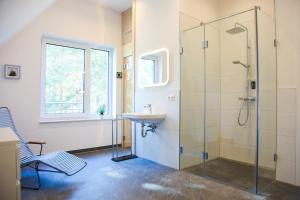 a bathroom with a glass shower and a sink at Ferienhaus Loddinperle mit Sauna in Loddin +19 photos