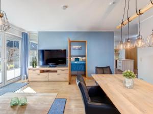 een woonkamer met een eettafel en een tv bij Ferienwohnung Maus in Ostseebad Koserow