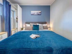 een slaapkamer met een blauw bed met een boek erop bij Ferienwohnung Maus in Ostseebad Koserow