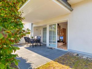 een huis met een terras met een tafel en stoelen bij Ferienwohnung Maus in Ostseebad Koserow