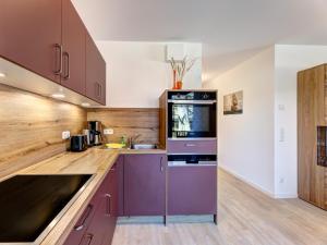 a kitchen with purple cabinets and a sink at Bernsteinquartier BQ 0548 in Kolpinsee