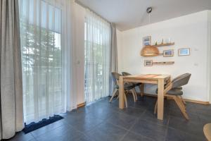 Ostseeresidenz Gorki- Park - 09 mit Wellness und Schwimmbad في بانسين: غرفة طعام بها طاولة وكراسي ونوافذ