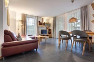 Ostseeresidenz Gorki- Park - 09 mit Wellness und Schwimmbad في بانسين: غرفة معيشة مع أريكة وطاولة وكراسي