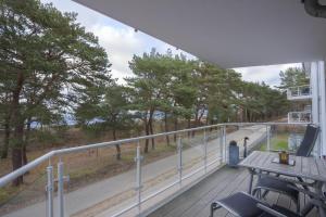 Ostseeresidenz Gorki- Park - 09 mit Wellness und Schwimmbad في بانسين: بلكونه فيها طاوله وكراسي واشجار