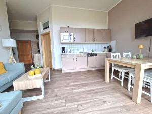 a kitchen and living room with a table and a blue couch at Bella Vita in Trassenheide