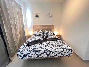 a bedroom with a bed with a black and white comforter at Villa Majunaxa in Corralejo