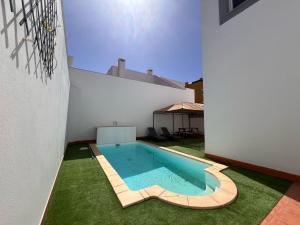 a swimming pool in the middle of a house at Villa Majunaxa in Corralejo
