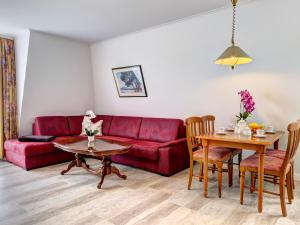 a living room with a red couch and a table at Seehof Wohnung 1.33 in Bansin