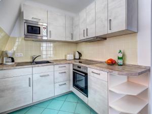 a kitchen with white cabinets and a sink at Seehof Wohnung 1.33 in Bansin