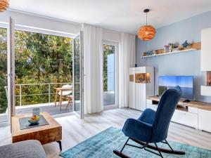 a living room with a blue chair and a table at Bernsteinquartier BQ 9c Ostseenest in Kolpinsee