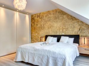 a bedroom with a large white bed with a stone wall at Bernsteinquartier BQ 9c Ostseenest in Kolpinsee