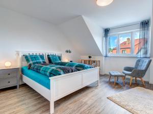een slaapkamer met een bed met blauwe lakens en een raam bij Bernsteinquartier BQ6b - Haus Lachmöwe in Kolpinsee