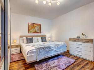 a bedroom with a large bed and a dresser at Villa Bellevue App. 8 in Ahlbeck