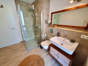 a bathroom with a sink and a shower with a mirror at Bernsteinquartier BQ1182 - Ankerplatz in Kolpinsee +13 photos
