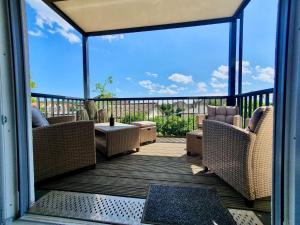 a porch with wicker chairs and a table on a balcony at Bernsteinquartier BQ1182 - Ankerplatz in Kolpinsee