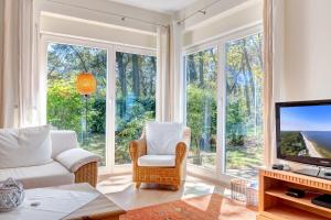 Il comprend un salon doté de grandes fenêtres et d'une télévision. dans l'établissement Haus Berlin Loddiner Höft, à Loddin