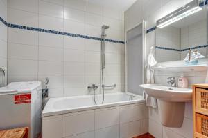 une salle de bain avec une baignoire, un lavabo et une douche dans l'établissement Haus Berlin Loddiner Höft, à Loddin 13 autres photos