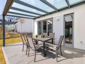 Un comedor con mesa y sillas en un patio. en Bernsteinquartier BQ 07e - Ferienhaus Meerzeit, en Kolpinsee