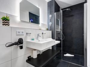 a bathroom with a white sink and a shower at Bernsteinquartier BQ0556 Meeresgold in Kolpinsee +14 photos