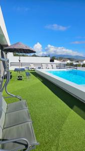 a patio with chairs and an umbrella and a pool at One of a Kind #PDL Luxury Retreat in Ponta Delgada