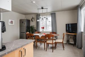 a kitchen and dining room with a table and chairs at Gasabäck Holiday Accomondation in Söråker