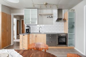a kitchen with stainless steel appliances and a wooden table at Gasabäck Holiday Accomondation in Söråker