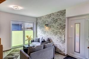 ロディンにあるHaus Füürtoorn mit Fass-Saunaの石壁のリビングルーム(ソファ付)
