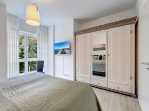 ein Schlafzimmer mit einem großen Bett und einem Fenster in der Unterkunft Bernsteinquartier BQ 0558 - Eichenkrone in Ostseebad Kölpinsee