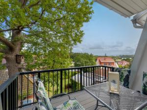 einen Tisch und Stühle auf einem Balkon mit einem Baum in der Unterkunft Bernsteinquartier BQ 0558 - Eichenkrone in Ostseebad Kölpinsee