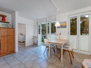 a kitchen and dining room with a table and chairs at Ferienwohnung Eichhorst in Trassenheide +4 photos