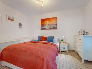 a white bedroom with a bed and a dresser at Ferienwohnung Eichhorst in Trassenheide
