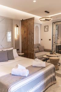 a bedroom with a large bed and a couch at Eros Luxury Suites in Rethymno Town +68 photos