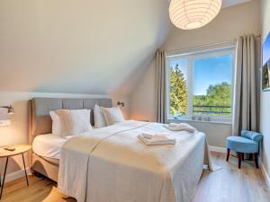 a bedroom with a bed and a window at Ferienhaus Fritz Reethus mit Sauna und Kamin in Loddin