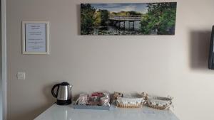 a table with baskets and a picture of a bridge at Chambre Rose Blanche in Le Lude