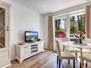 ein Wohnzimmer mit einem TV und einem Tisch mit Stühlen in der Unterkunft Hansehus Ferienwohnung Nr 3 in Zinnowitz