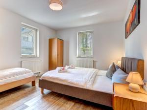 ein Schlafzimmer mit einem Bett und zwei Fenstern in der Unterkunft Hansehus Ferienwohnung Nr 3 in Zinnowitz