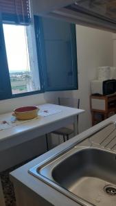 a kitchen counter with a sink and a window at residence specchia in Specchia