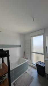 un bagno con vasca e finestra di Appartement contemporain lumineux avec terrasse a Vitré Altre 2 foto