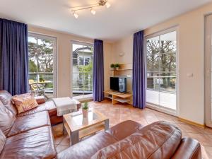 Una sala de estar con un sofá y un televisor. en Ostseeresidenz Gorki- Park - 06 mit Wellness und Schwimmbad, en Bansin