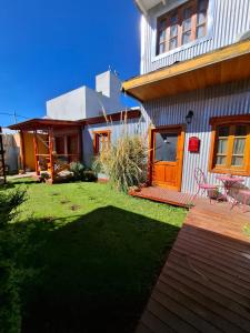 a backyard with a house and a lawn at Marina Bella Habitación 2 in Rada Tilly