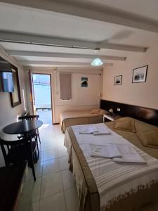 una habitación de hotel con dos camas y una mesa en Marina Bella Habitación 2, en Rada Tilly