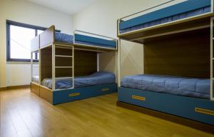 two bunk beds in a room with a window at Hostel EntryFik in Maçeira