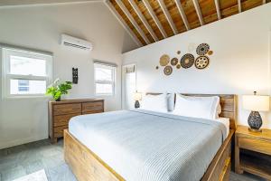 a bedroom with a large bed and two windows at Cameys House and Pool Club at Mahogany Bay in San Pedro +25 photos