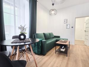 a living room with a green couch and a table at ZA FLORĄ in Jelenia Góra