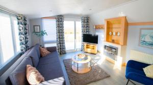 a living room with a blue couch and a tv at MP261 Parkdean Camber Sands in Camber