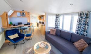 a living room with a blue couch and a desk at MP261 Parkdean Camber Sands in Camber +10 photos
