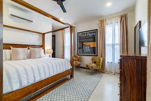 a hotel room with a bed and a television at Casa Playa de Denver + Pool Club at Mahogany Bay in San Pedro +25 photos